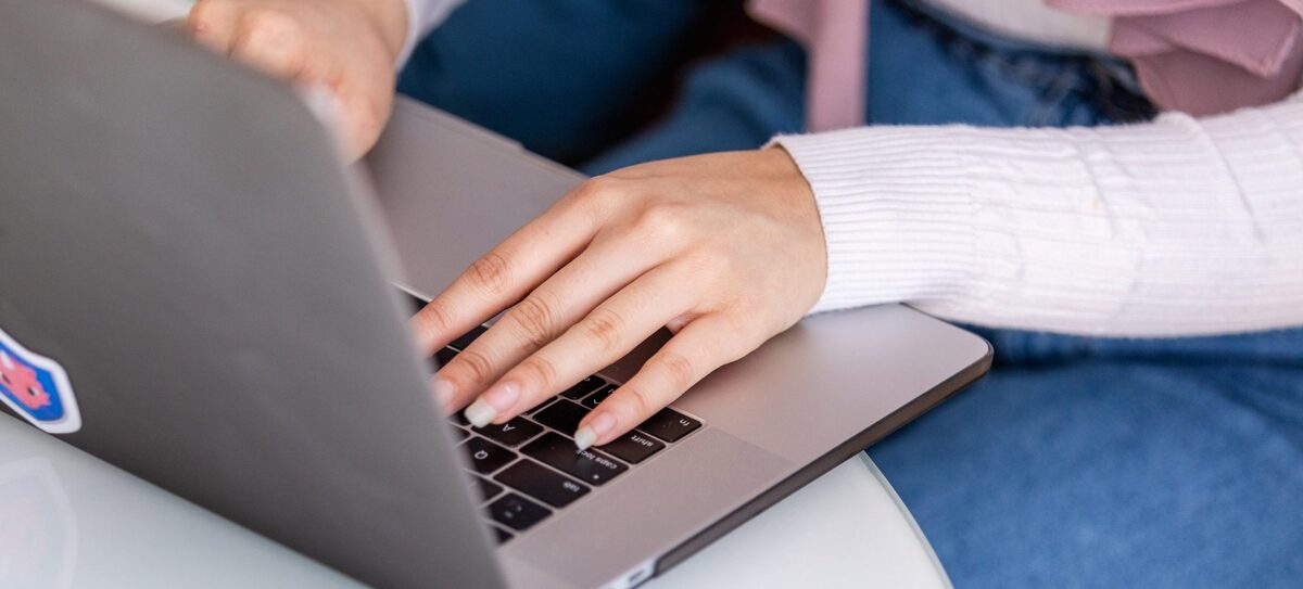 Woman sits at table working on laptop