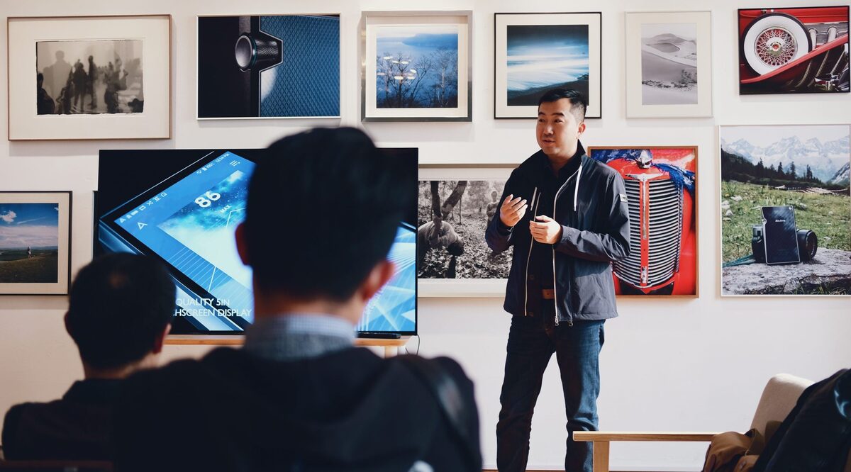 Man beside flat screen television with photos background