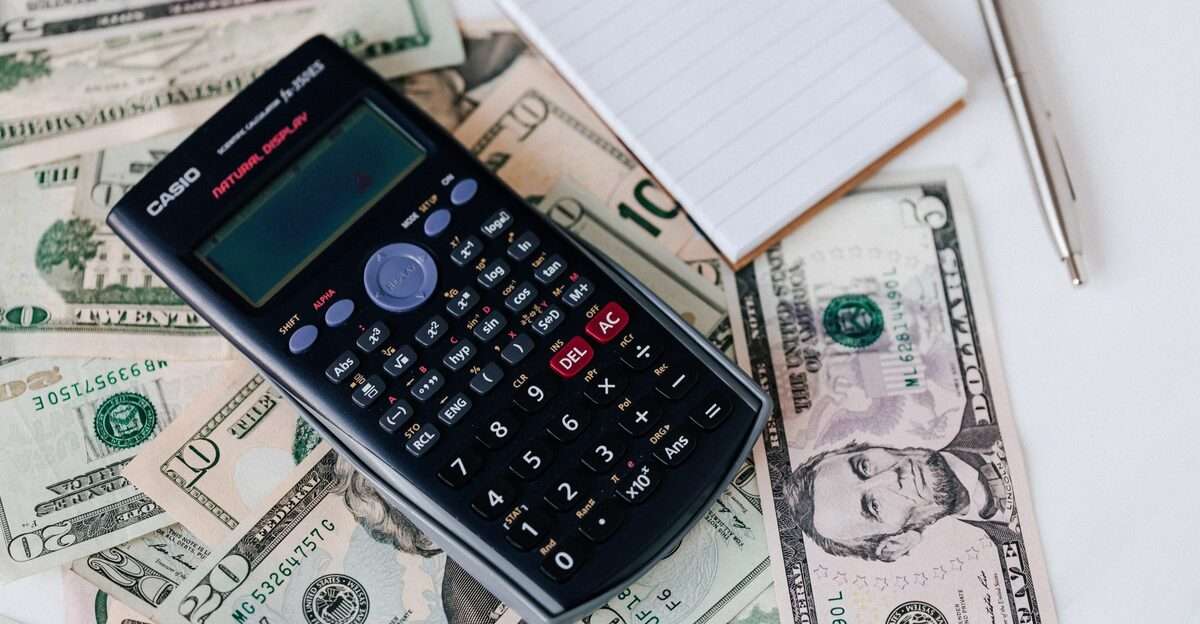 Calculator and notepad placed on usa dollars stack
