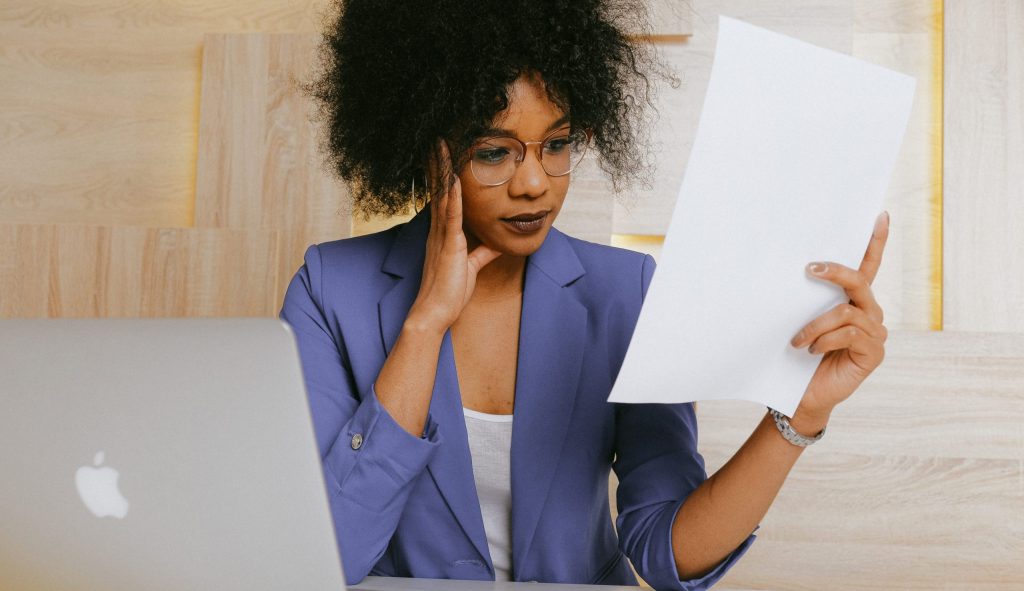 Woman in blue blazer holding white paper