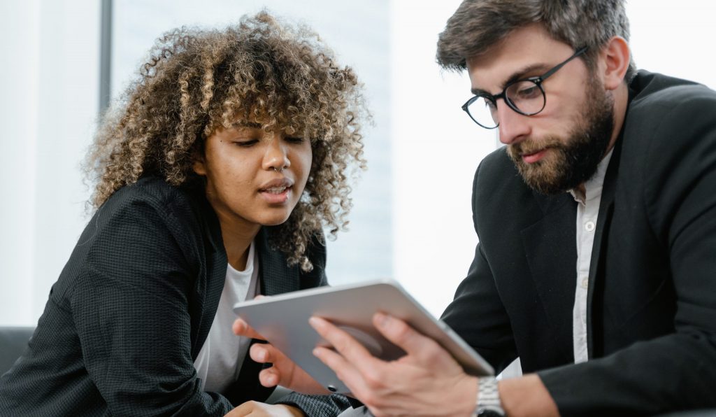 Man in black suit jacket holding black tablet computer